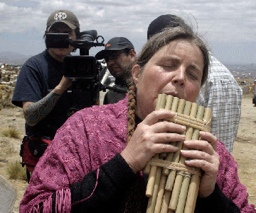 Lynette
                                        Yetter, as Lucy, plays panpipes
                                        on location in Bolivia, filming
                                        Panpipes for Peace